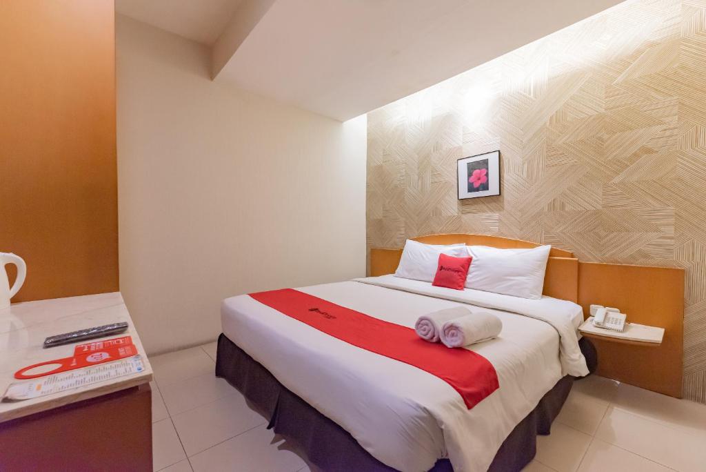 um quarto de hotel com uma cama com toalhas em RedDoorz Plus @ Cipaganti Street 3 em Bandung