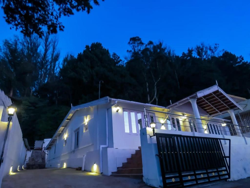a house with lights on the front at night at Heaven Bungalow in Ooty