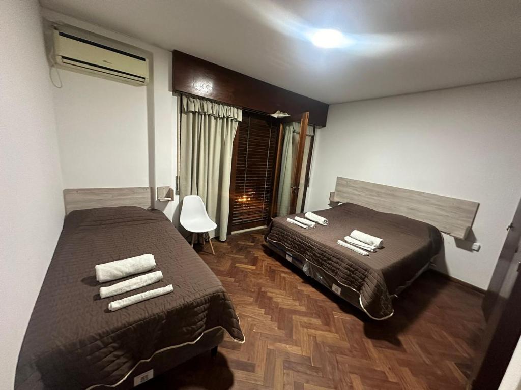 um quarto de hotel com duas camas e uma janela em Hostel San Vicente em Salta
