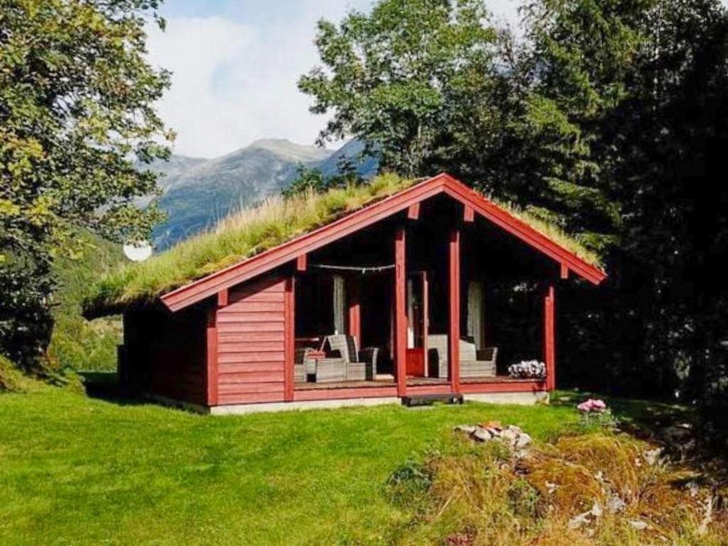 a small red cabin with a grass roof at 6 person holiday home in olden in Olden