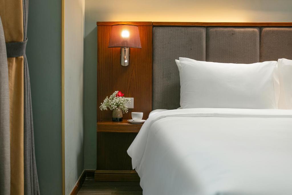 Postel nebo postele na pokoji v ubytování GRAND CITITEL Hanoi Hotel & Spa
