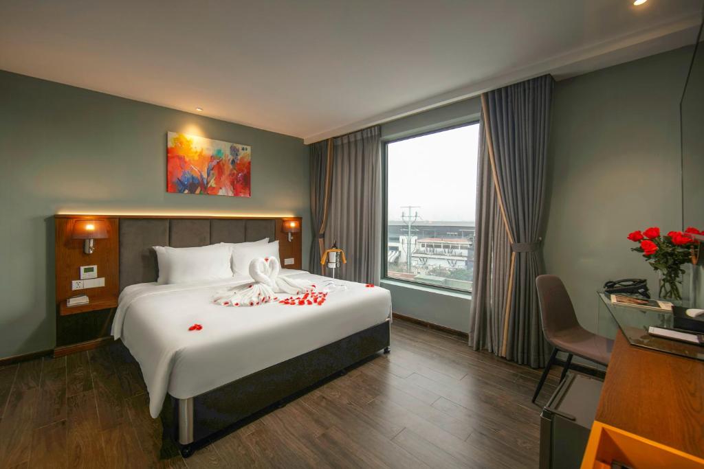 a bedroom with a large bed and a large window at Grand Cititel Hanoi Hotel & Spa in Hanoi