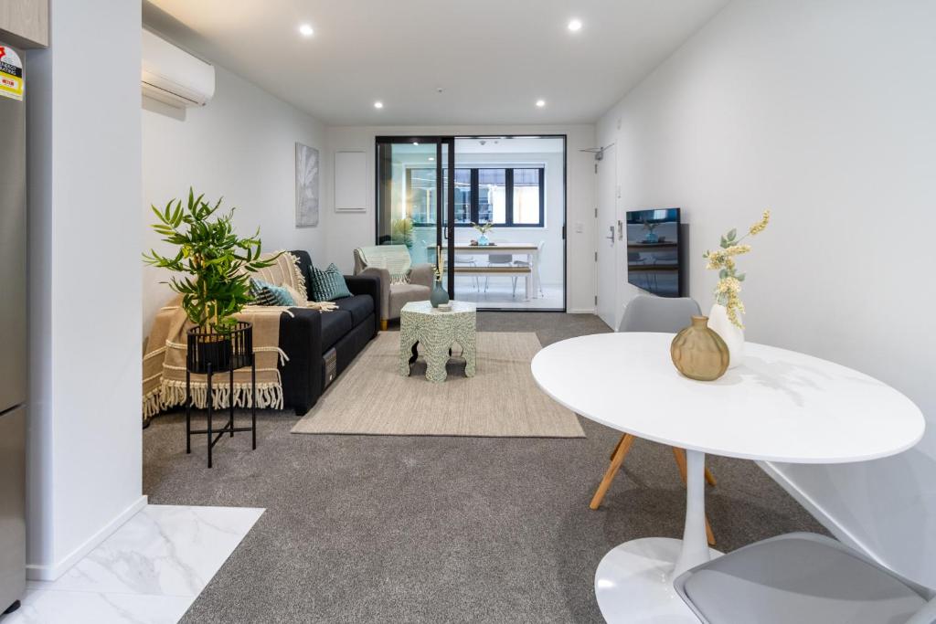 ein Wohnzimmer mit einem Sofa und einem Tisch in der Unterkunft Style meets comfort 2 Bed CHCH CBD in Christchurch