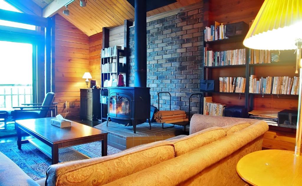 a living room with a couch and a fireplace at Renesto aHOLIDAYHOME - Vacation STAY 27971v in Kobe