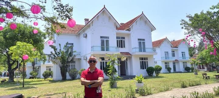 a man standing in front of a large house at Sen Vàng in Diễn Châu