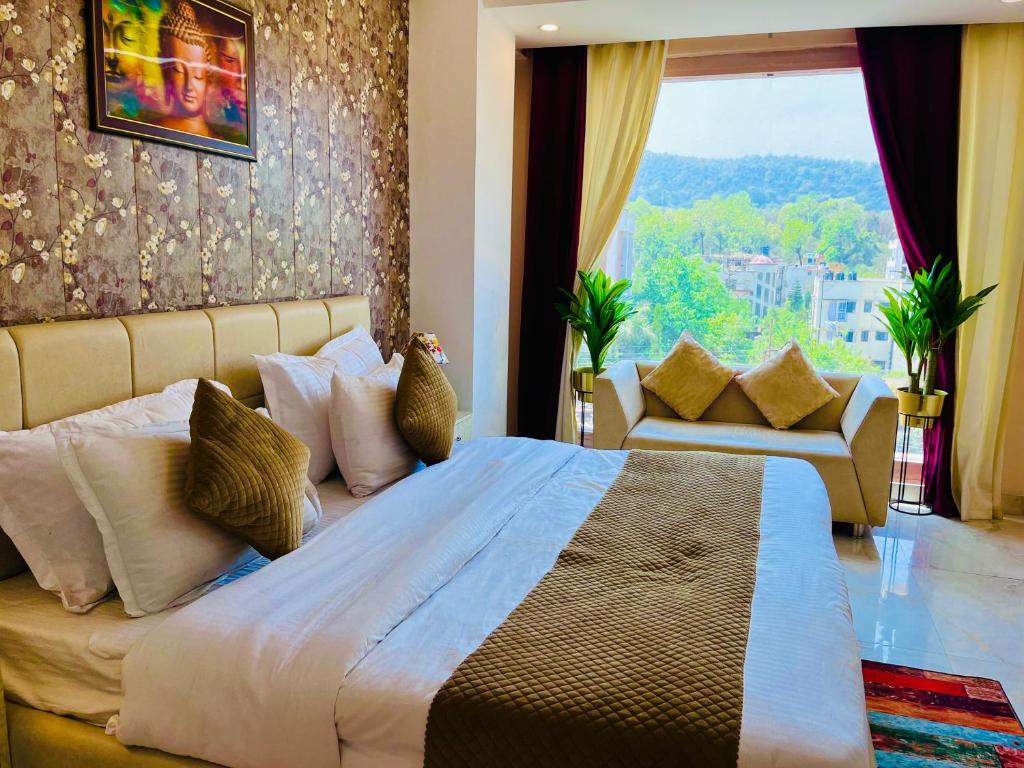 a bedroom with a large bed and a large window at The Tirath Palace Luxury Hotel In Haridwar in Haridwār