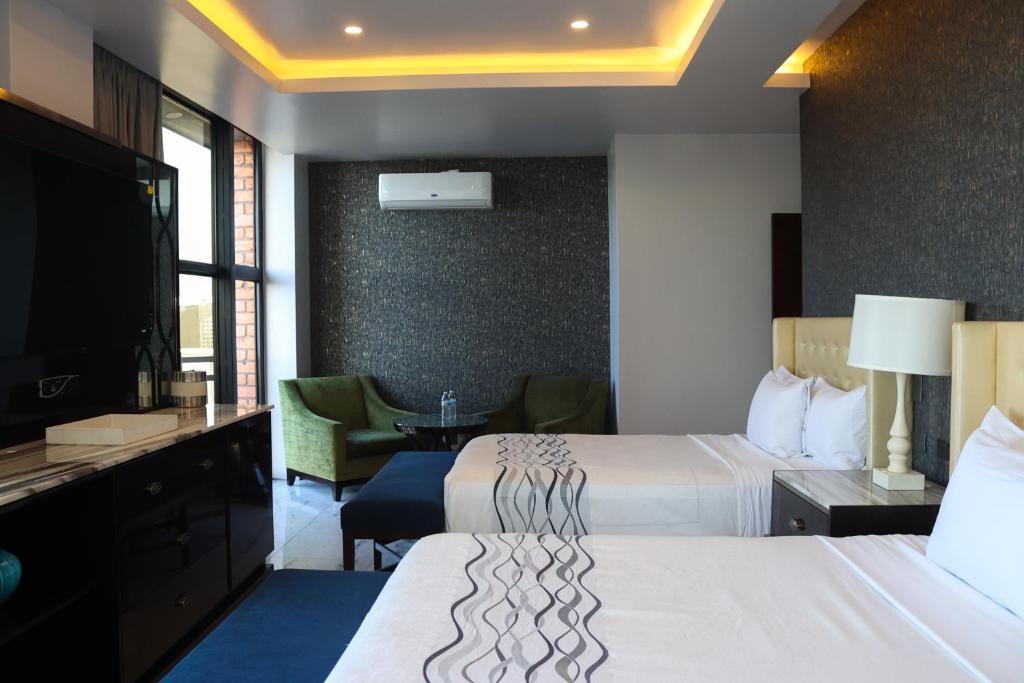 ein Hotelzimmer mit 2 Betten und einem TV in der Unterkunft Hotel Wellintown in Tijuana