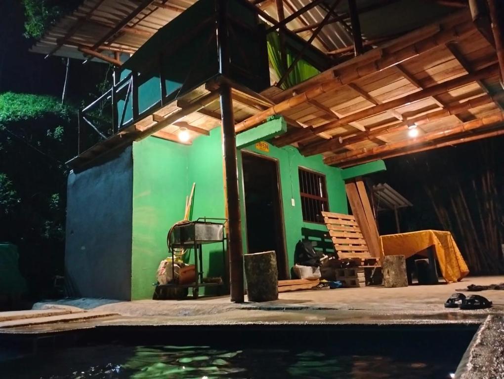 ein Haus mit einer grünen Wand neben einem Pool in der Unterkunft REFUGIO EN EL BOSQUE in Cisneros