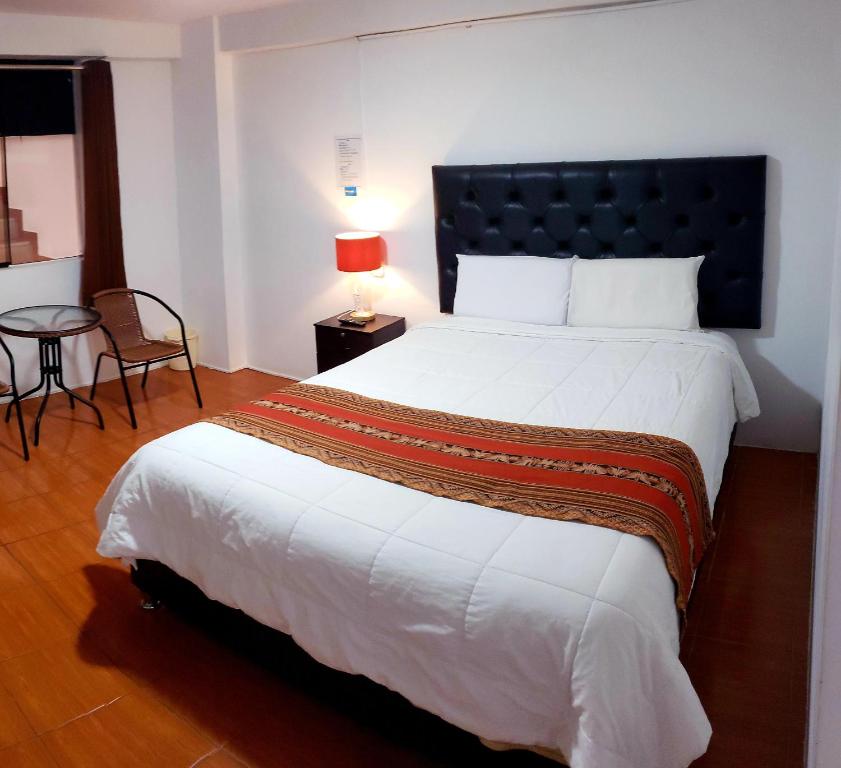 um quarto com uma cama grande e uma mesa em Cusco de mis Sueños Hostal - II em Cusco