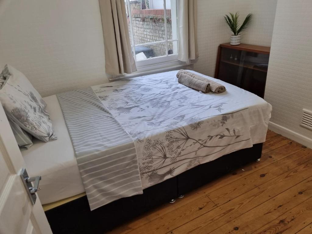 a bed in a room with a window at Refurbished Double Bedroom in London