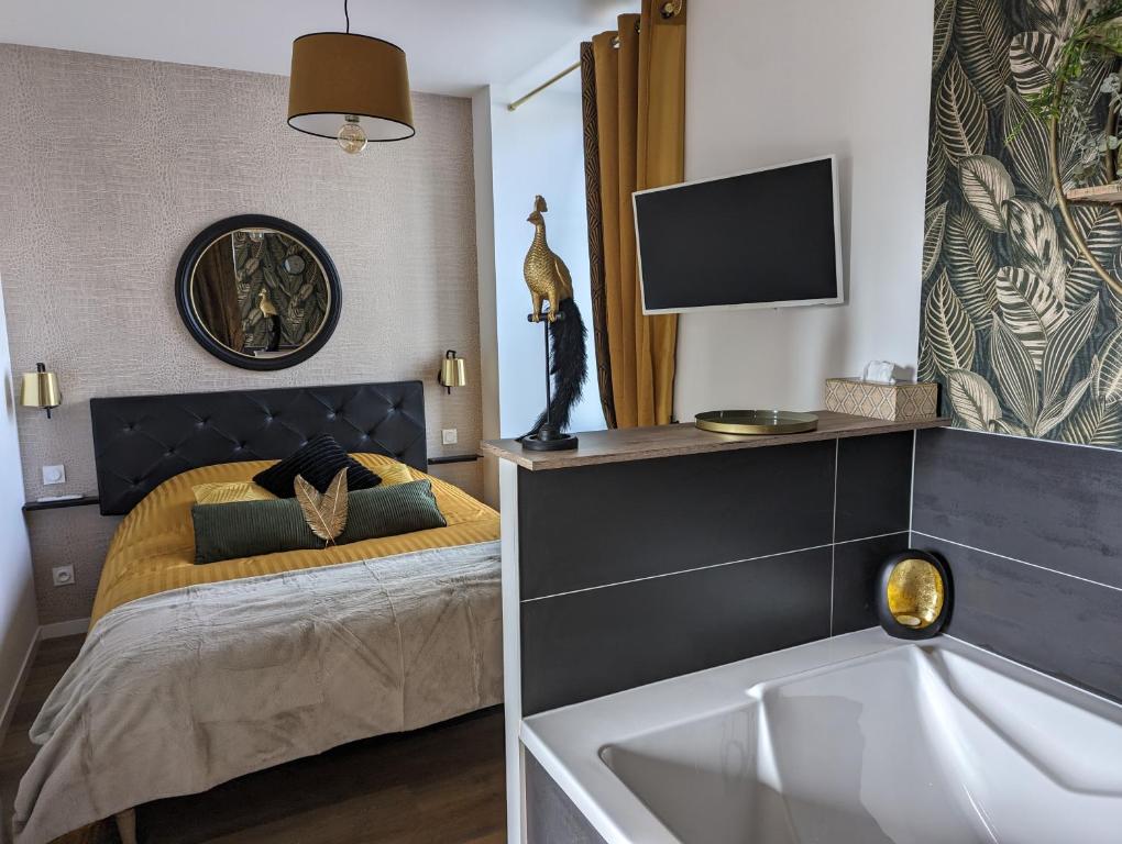 ein Schlafzimmer mit einem Bett mit einem Waschbecken und einem TV in der Unterkunft la Pléiade in Pont-Hébert