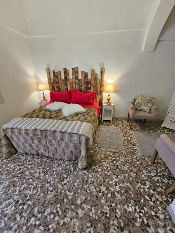 una camera da letto con un grande letto con cuscini rossi di Ceglie Antica a Ceglie Messapica