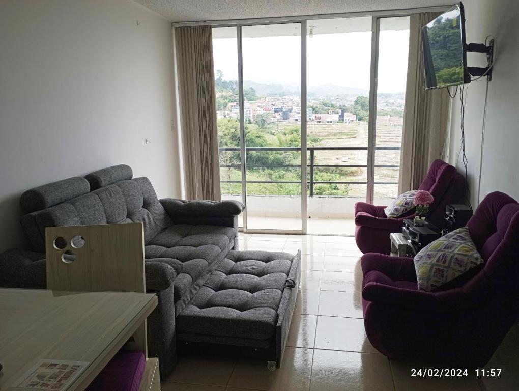 sala de estar con sofá, sillas y ventana grande en Santa Rosa De Cabal - Acogedor apartamento, en Santa Rosa de Cabal