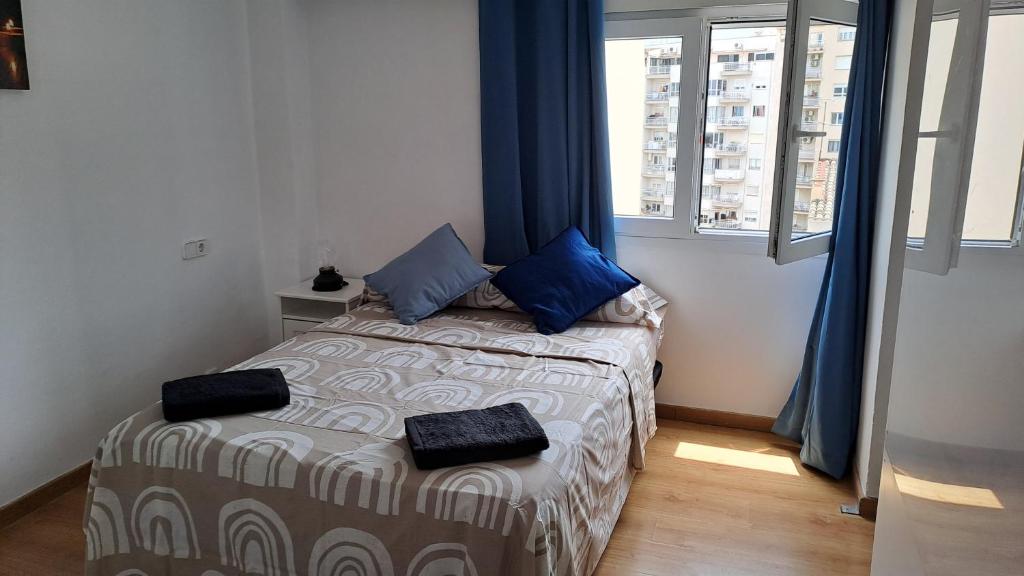 Habitación pequeña con cama con almohadas azules. en Home & Away en Palma de Mallorca