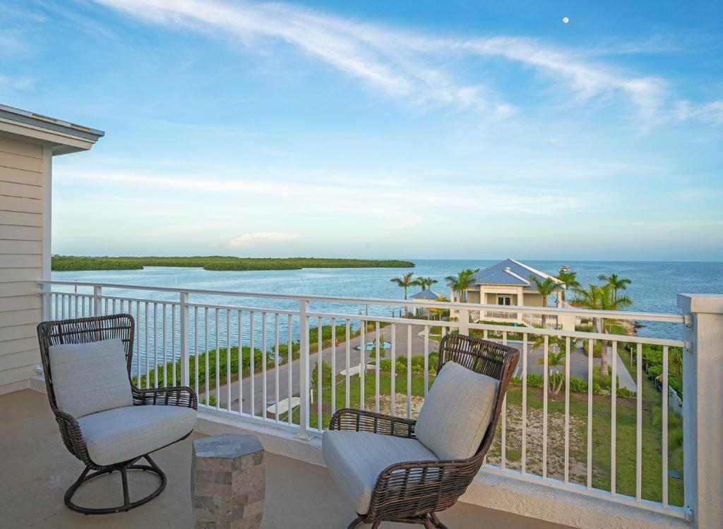 a balcony with two chairs and a view of the ocean at The Sea Haven 4br-4,5ba in Key Largo
