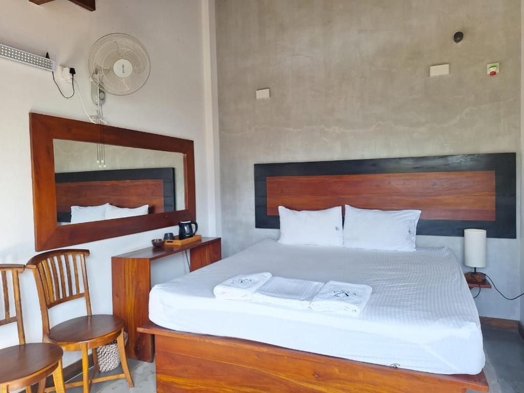 a bedroom with a large bed with a wooden headboard at Bellaxy Ceylon in Ella