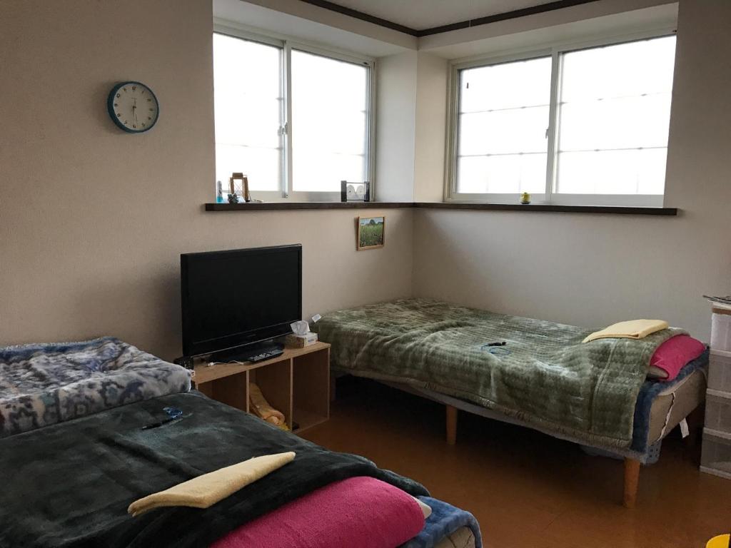 a room with two beds and a tv and windows at Misato Memorial Hall - Vacation STAY 61405v in Hirakawa