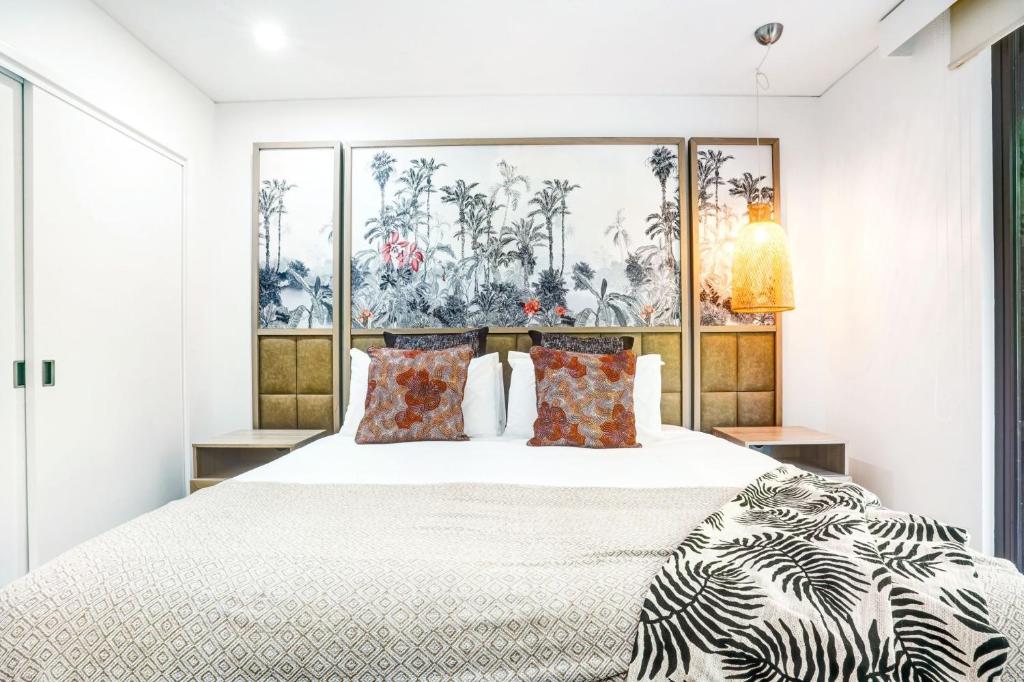 a bedroom with a large white bed with pillows at 235 Temple Tranquility Triton Retreat in Palm Cove