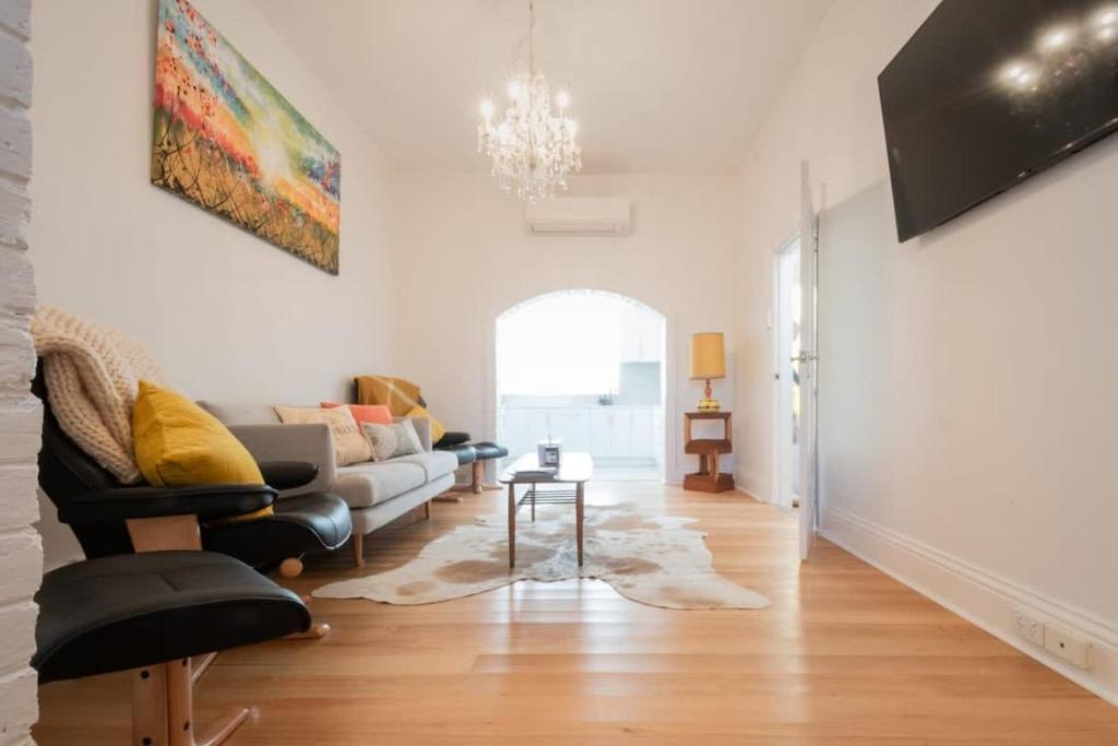 a living room with a couch and a table at Historic Beauty in the CBD with Parking & WiFi in Launceston