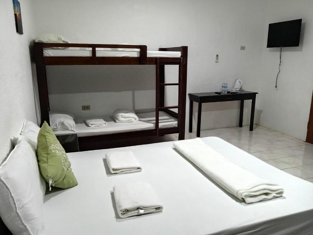 een slaapkamer met een bed met 2 stapelbedden bij Moalboal Beach Front Hotel in Moalboal