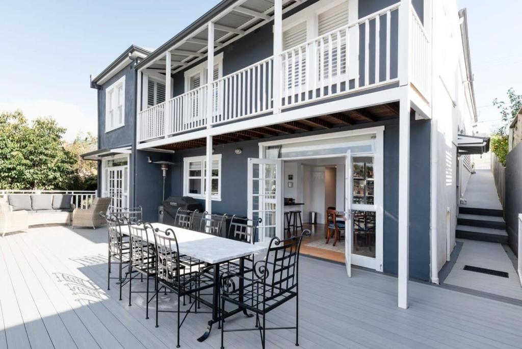 Casa con terraza con mesa y sillas en Lovingly Restored Hampton's Haven, en Kings Park