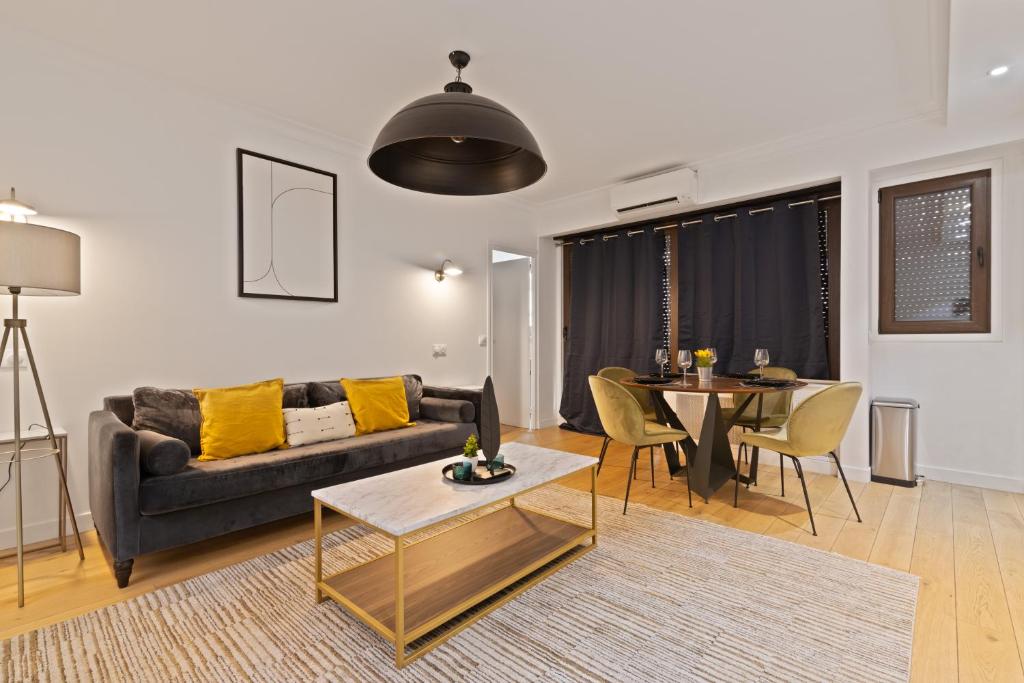 un salon avec un canapé et une table dans l'établissement Appartement Quartier Arc de Triomphe 4 Free Netflix, à Paris