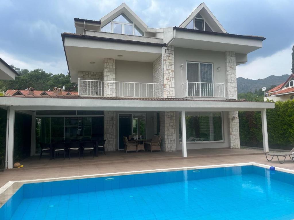 a house with a swimming pool in front of it at blue depth villa in Fethiye