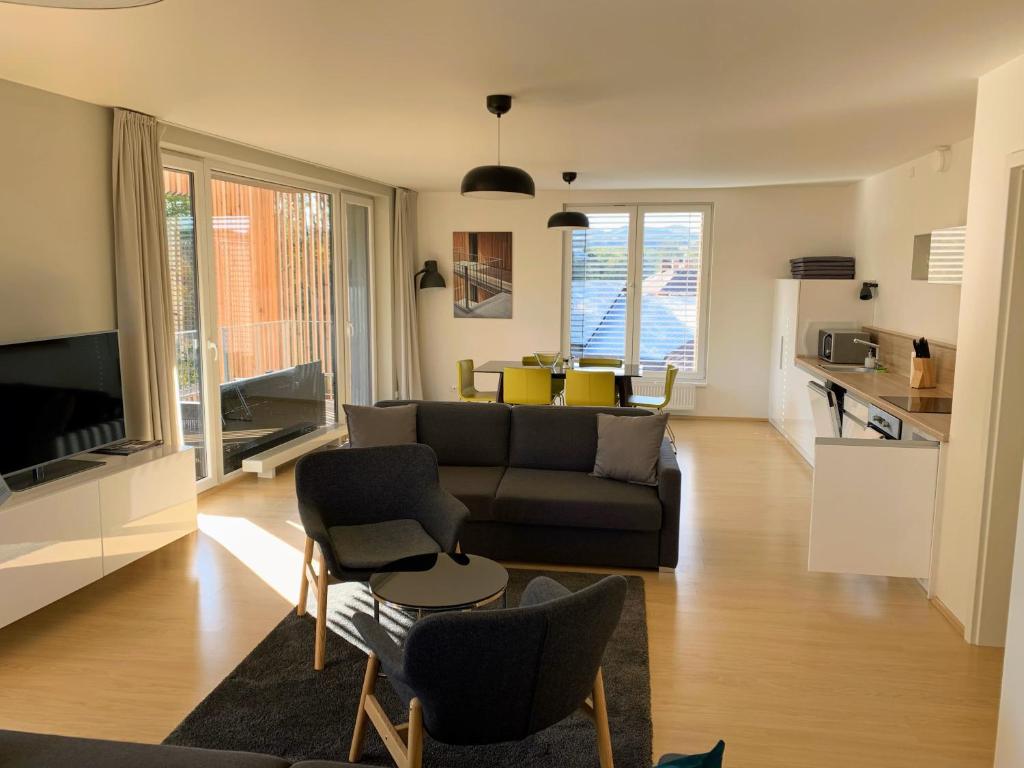 a living room with a couch and some chairs at Lakepark Residence in Staré Splavy