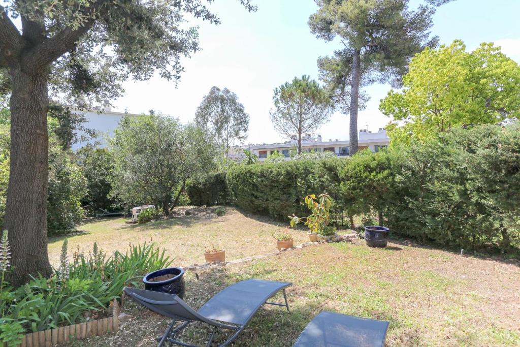 une cour avec deux chaises et un arbre dans l'établissement Charming & bright flat with AC Garden 300m and Closed Garage - BENAKEY, à Cannes