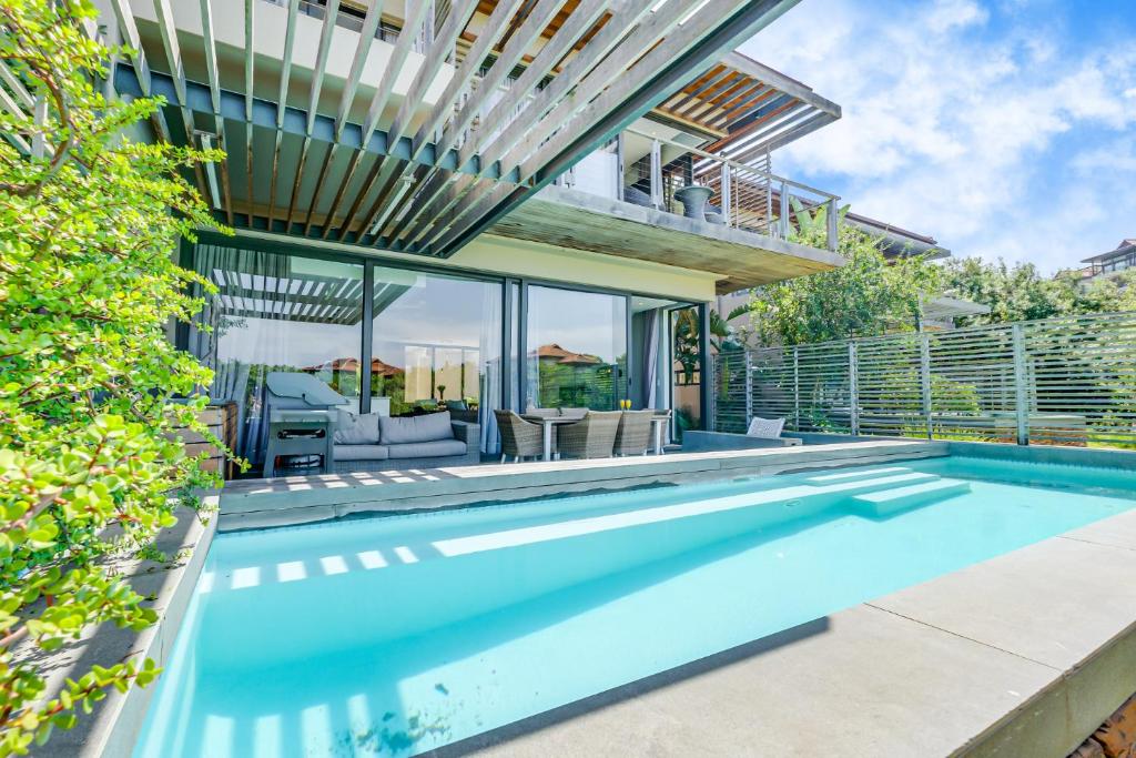 uma piscina interior numa casa com um pátio em Oceans Edge 4, Zimbali Estate em Ballito