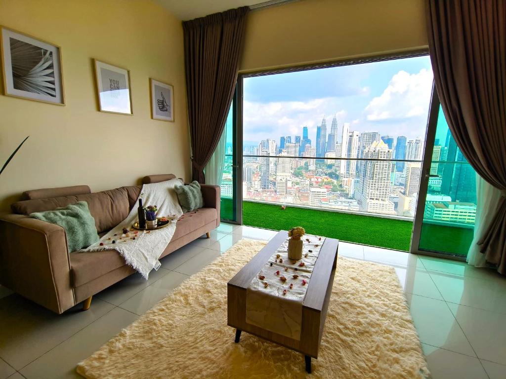 uma sala de estar com um sofá e uma grande janela em KLCC view WTC 5Pax 2BR Balcony RR327 R em Kuala Lumpur