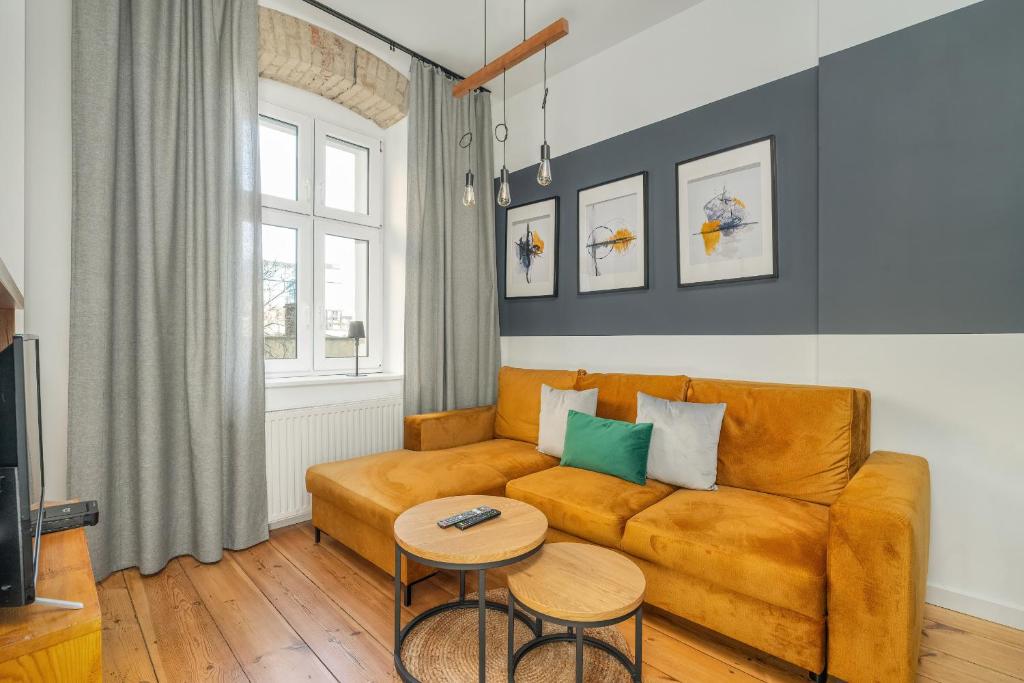 een woonkamer met een bank en een tafel bij Elegant Apartment near to the Centre of Poznań by Rent like home in Poznań
