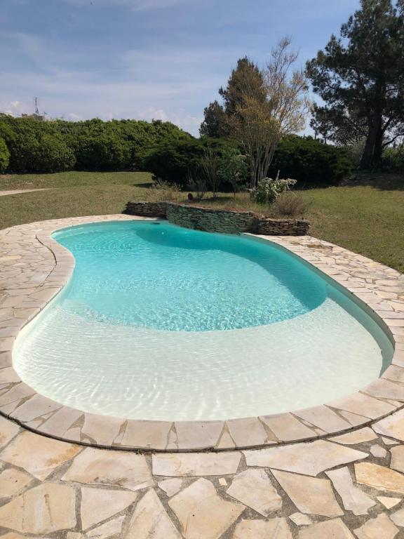 ein großer Pool mit einem Steinweg um ihn herum in der Unterkunft Maison climatisée piscine salle de sport 8/9 pers. in Monteux