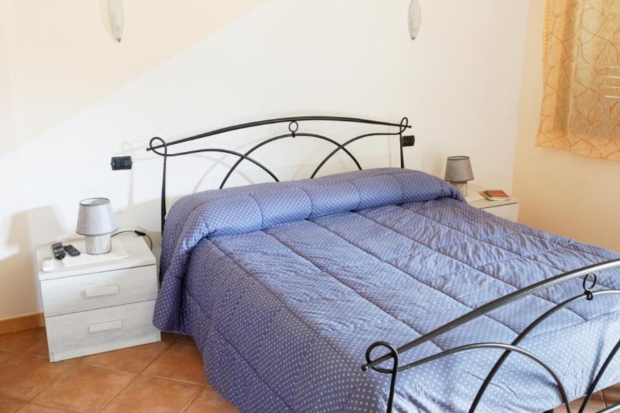 - un lit avec une couette bleue dans une chambre dans l'établissement Agriturismo S'Ispiga, à Cuglieri