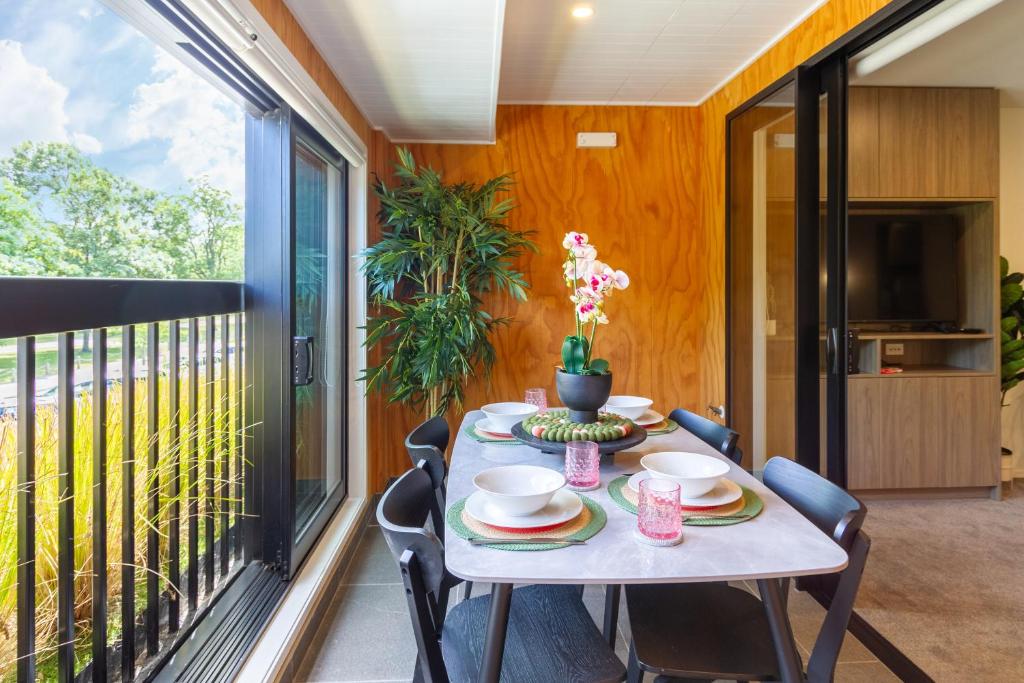 a balcony with a table and chairs and a television at Cozy 1-Bed Apartment with Park Views, Sleeps 4 in Christchurch