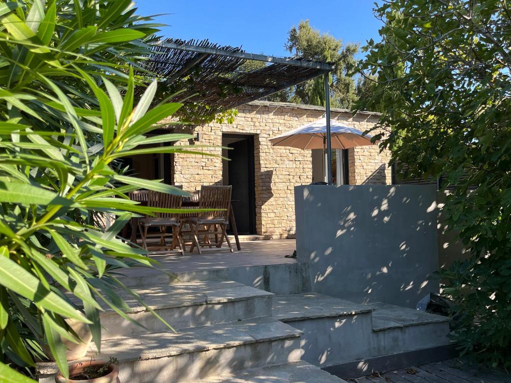 un patio avec une table et un parasol dans l'établissement Magnifique Bergerie en Pierre, à Brando