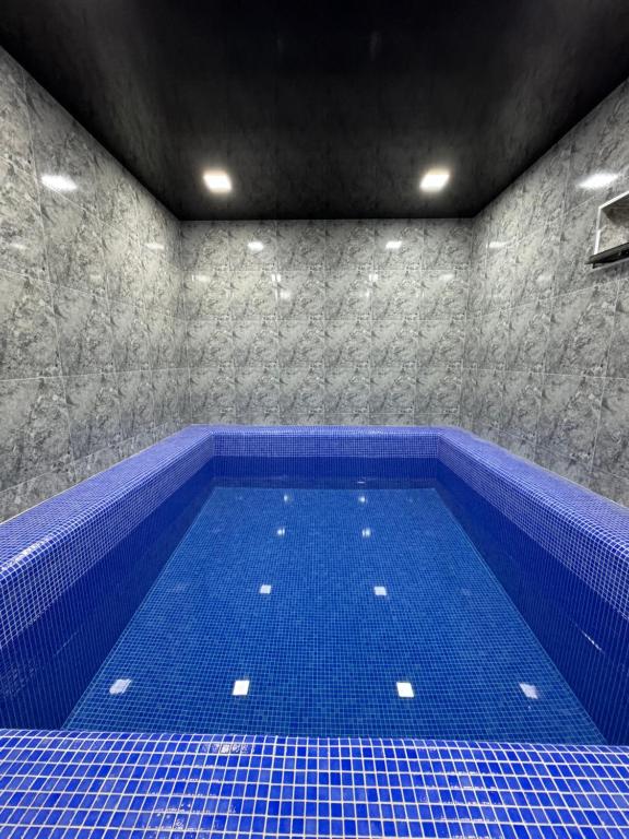 a large blue swimming pool in a room at “DACHA” Hi-Tech by Dubai in Aranchi