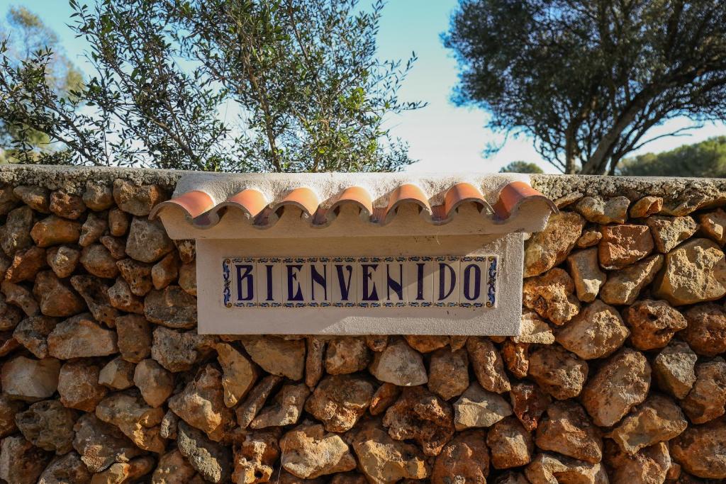un letrero de la calle en una pared de piedra en Son Mestres de Baix, en Cala Galdana