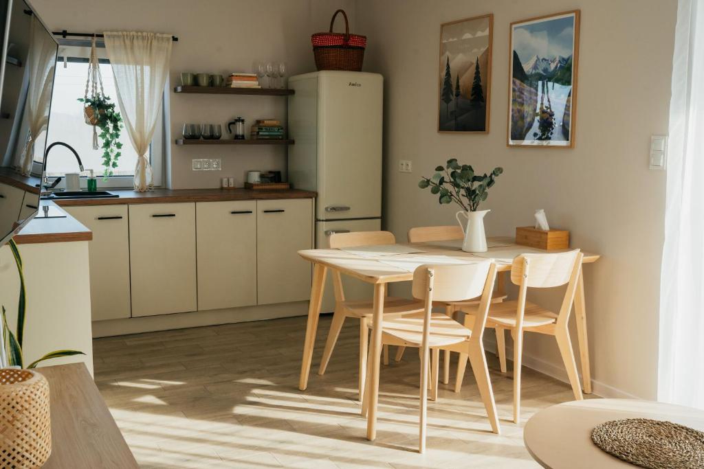 een keuken met een tafel en stoelen en een koelkast bij Apartament ACTIV jezioro góry in Żywiec