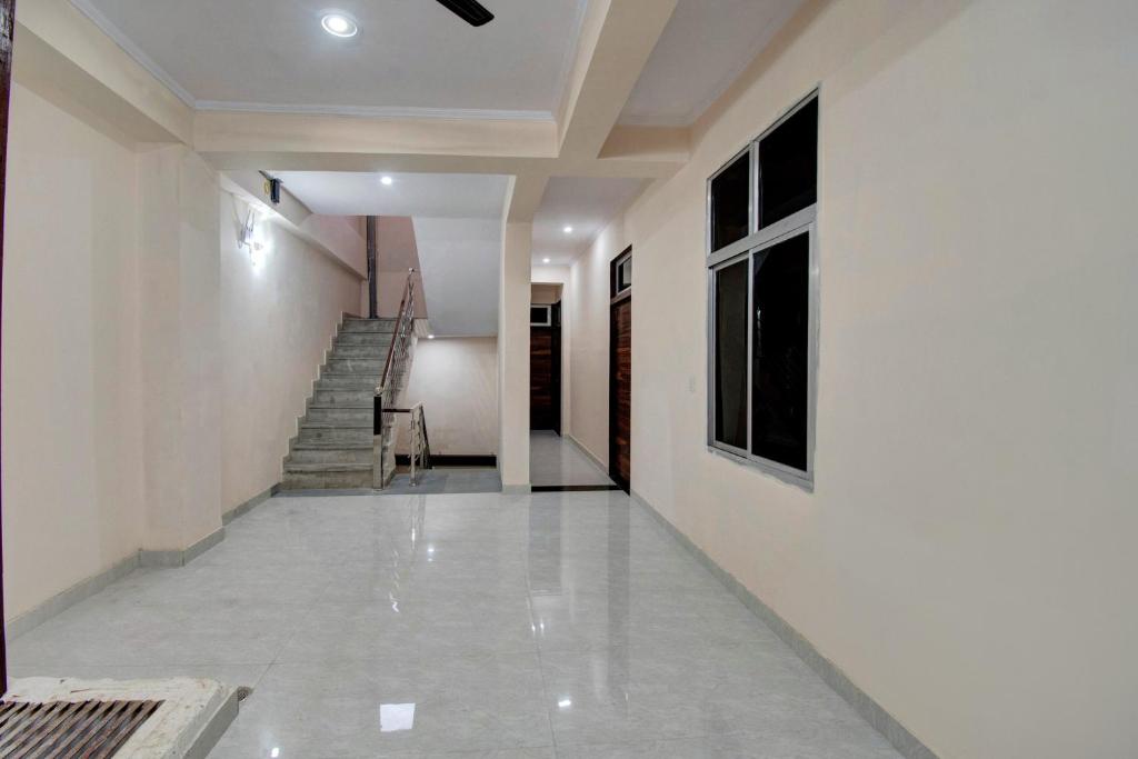 um corredor com paredes brancas e uma escada em Shree Shyam Palace em Jaipur