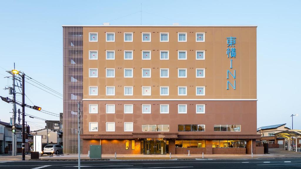 d'un grand bâtiment brun avec un panneau. dans l'établissement Toyoko Inn Gotemba Ekimae, à Gotemba