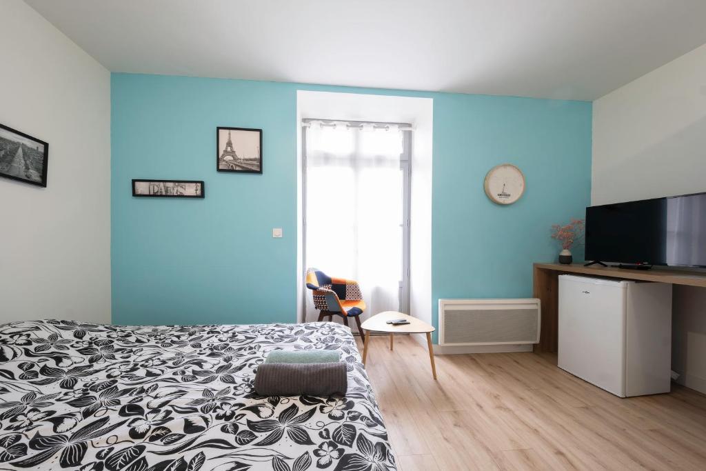 um quarto com uma cama e uma parede azul em Segré centre ✰ studio ✰ 24m² ✰ cuisne ✰ wifi ✰ TOUT NEUF! em Segré