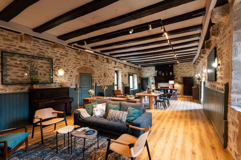 een woonkamer met een bank en stoelen bij La Maison OBONO Hôtel & Spa in Le Bono