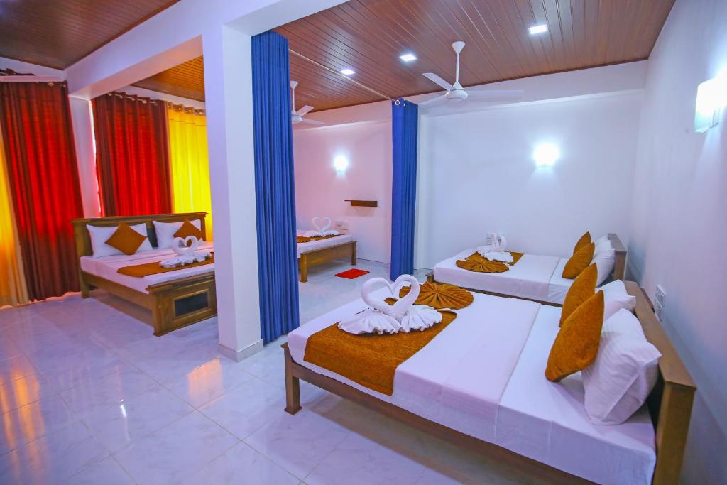 Ella Sriya Holiday Resort في إيلا: غرفة نوم بسريرين في غرفة