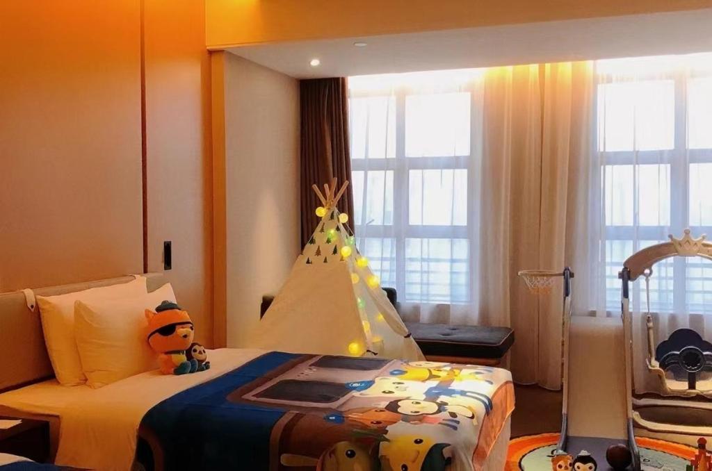Un dormitorio con una cama con un sombrero de cumpleaños. en Atour Hotel Zhanjiang Renmin Avenue Dingsheng Plaza, en Zhanjiang