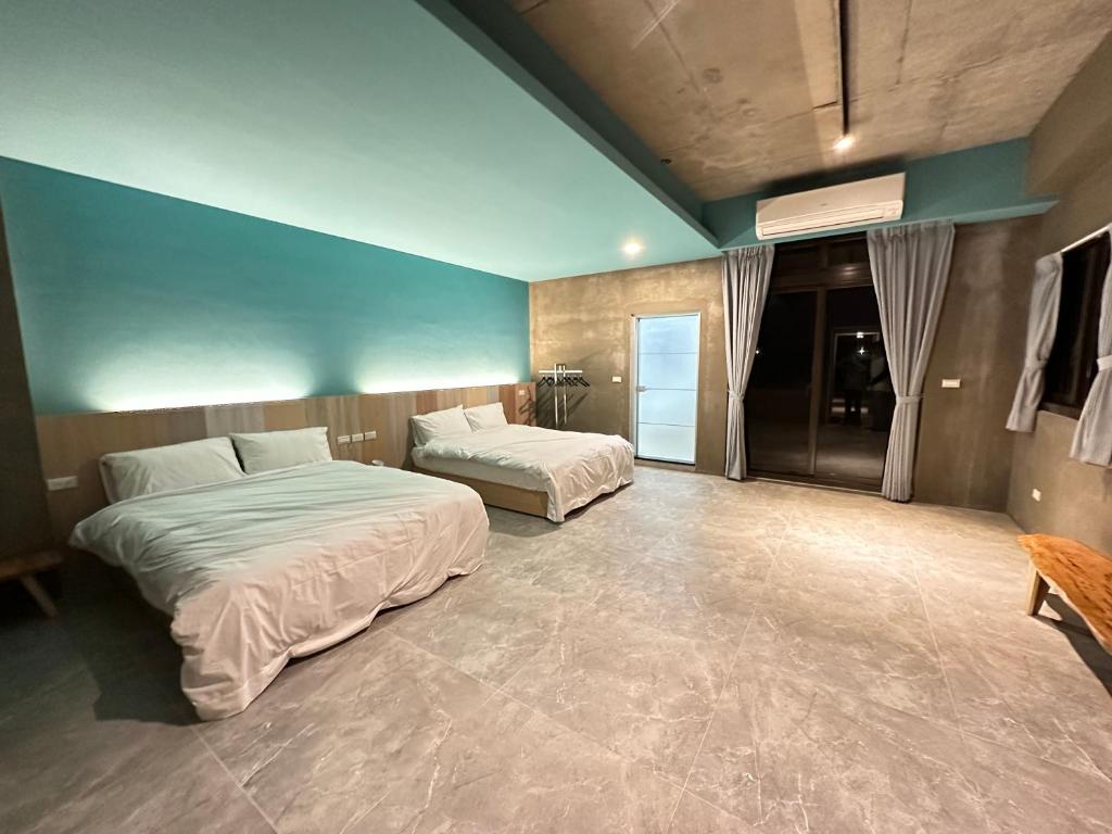 1 dormitorio con 2 camas y pared azul en 21 Tao Heung Homestay, en Jiaoxi