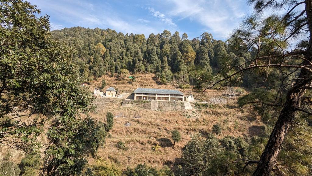 a house on a hill in the middle of a forest at MudHouse Retreat, Sarajara in Bīr