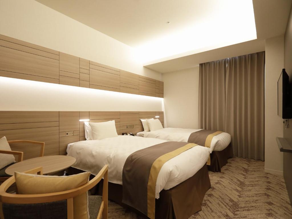 a hotel room with two beds and a table at Nihon Seinenkan Hotel in Tokyo