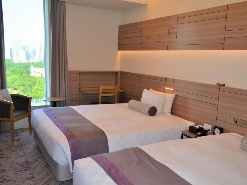 Postel nebo postele na pokoji v ubytování Nihon Seinenkan Hotel