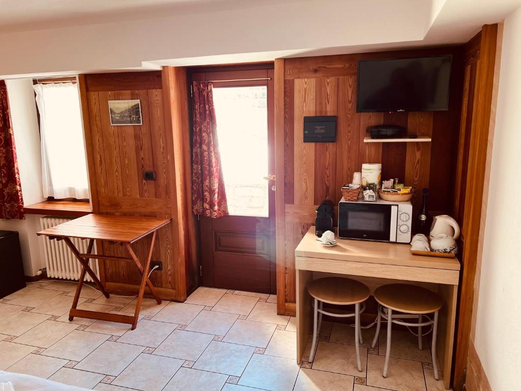 a small kitchen with a table and a microwave at Affittacamere Buenavista in Champoluc